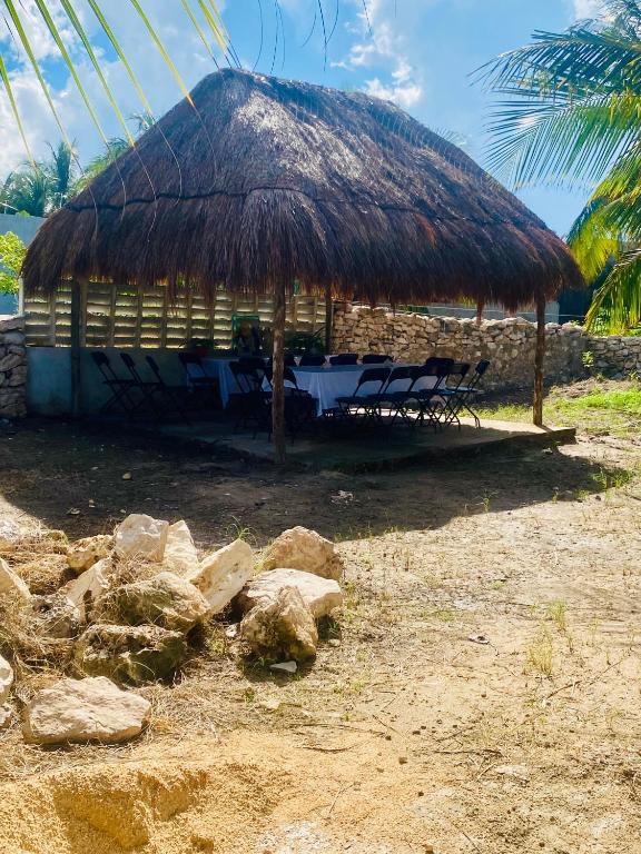 a hut with chairs and rocks in front of it at Cabañas Puertas del Sol in Telchac