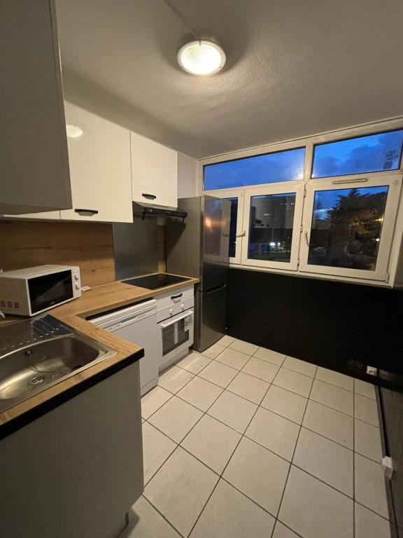 a kitchen with a sink and a counter top at Location chambre idéal travailleur étudiant Evry 1 personne in Courcouronnes