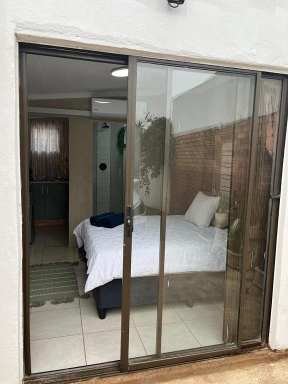 a bedroom with a bed through a sliding glass door at Ocean Village - No Sea View in Amanzimtoti