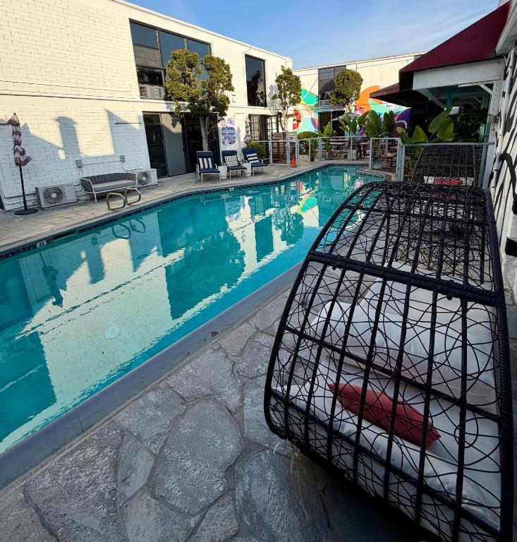 a bird cage sitting next to a swimming pool at Park Plaza Lodge in Los Angeles