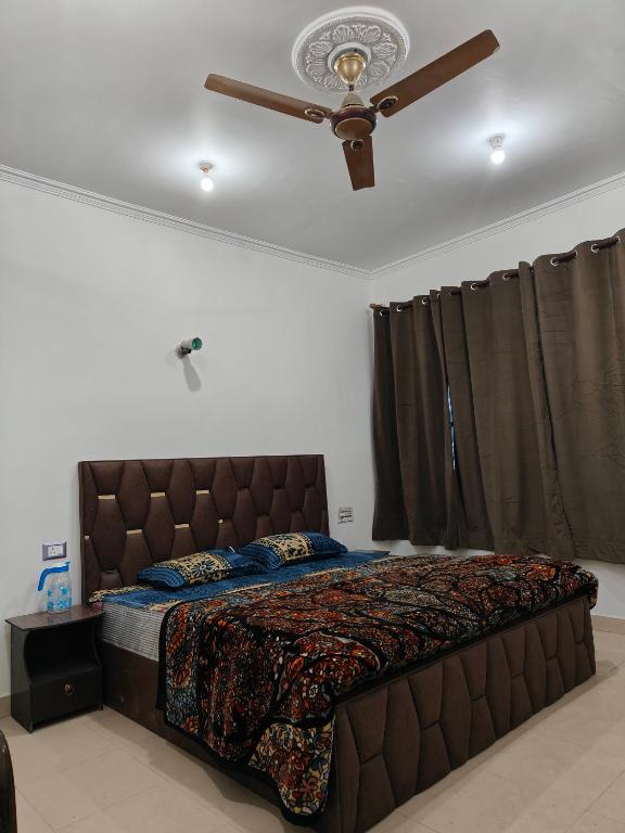 a bed in a bedroom with a ceiling fan at Hotel Sada Bahar in Srinagar