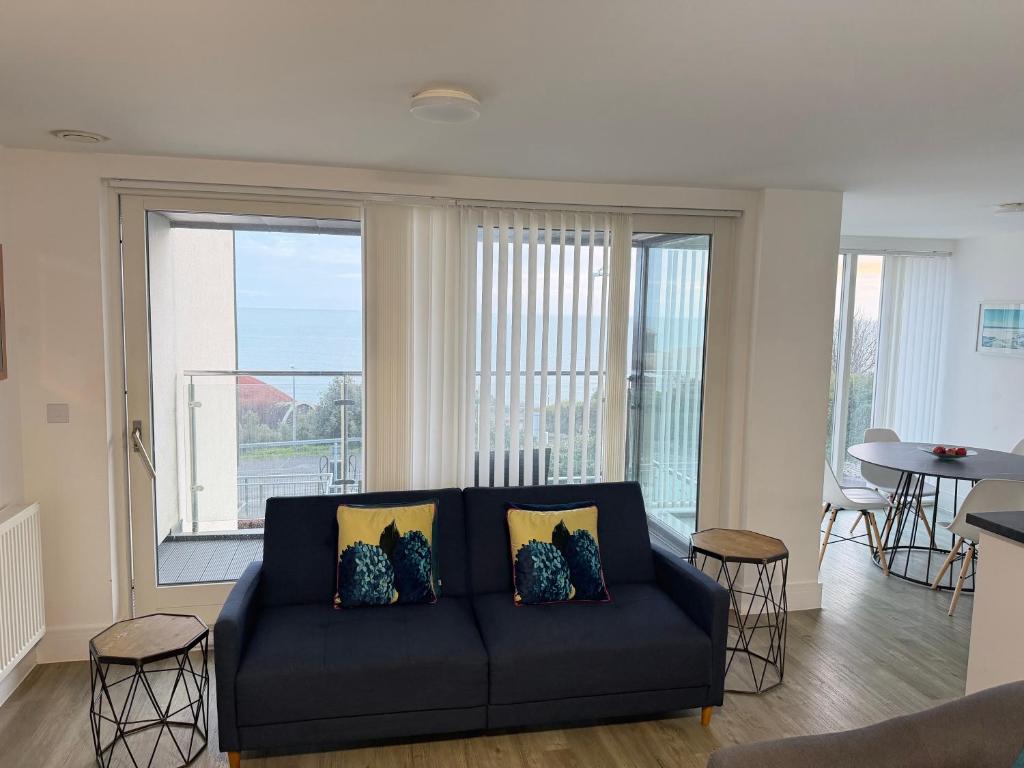 a living room with a couch and a large window at Seaview West Coast - Exceptional - 2 Bedrooms Sleeps 5 -Stunning Sea Views - 500 metres to Beach in Bournemouth