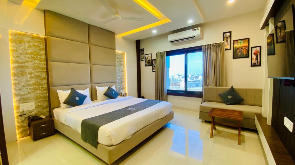 a bedroom with a large bed and a window at Hotel Madhur Pithampur in Akolia