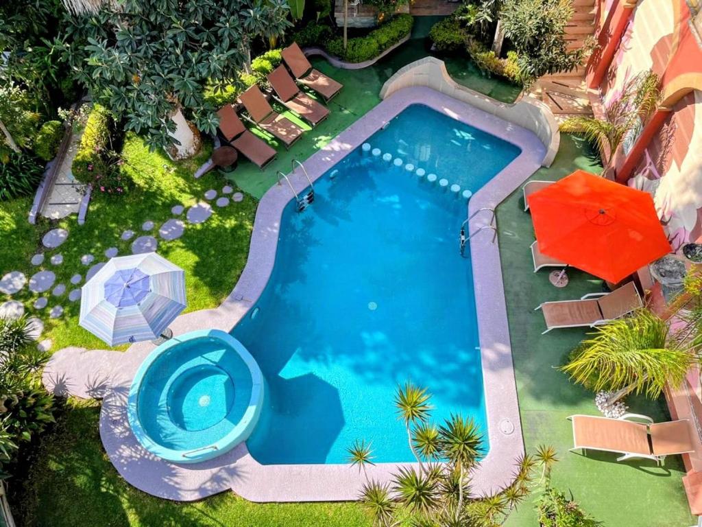 an overhead view of a swimming pool with an umbrella at Hotel Cuellar in Tula de Allende