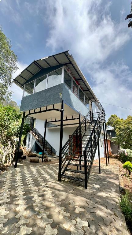 a building with a staircase in front of it at Cloud Crest Homestay in Ooty