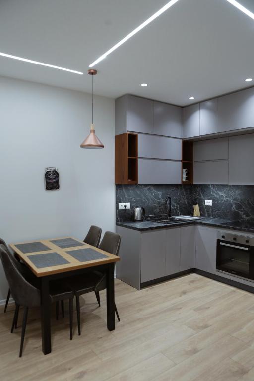 a kitchen with a table and chairs in a room at Shehu Apartments in Tirana