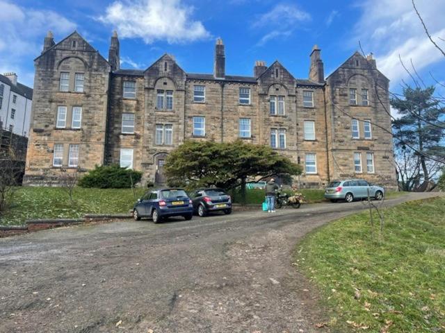 a large brick building with cars parked in front of it at Hidden Gem in Stirling