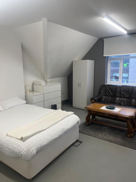 a bedroom with a bed and a couch and a table at The Stag and Hen Pub in Coventry