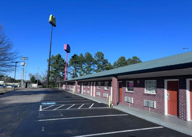 an empty parking lot next to a red brick building at Deerfield inn & Suits in Smyrna