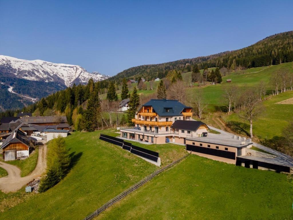 an aerial view of a large house on a green field at Top 103 Lärchenhof in Mauterndorf