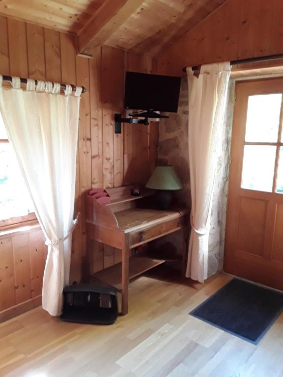 una camera con scrivania in una cabina con finestra di L'AUBERGE CHEZ LEON a Le Chambon-sur-Lignon