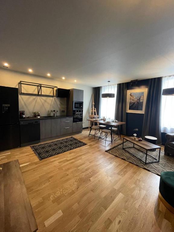 a living room with a table and a kitchen at Grand Appartement Hyper Centre in Lens