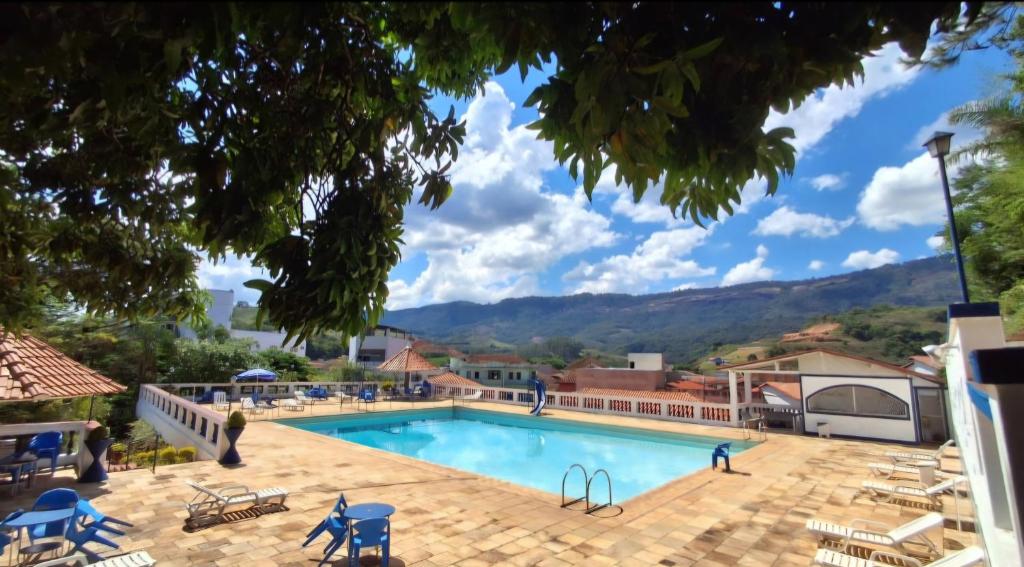 a pool at a resort with mountains in the background at Recanto da Serra Imperial in Lambari