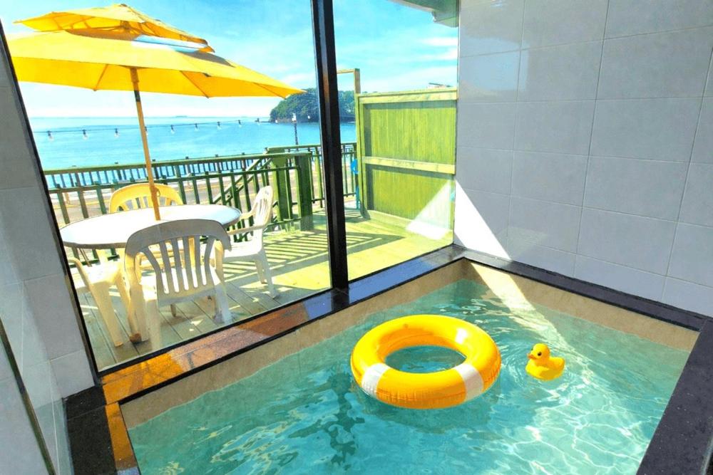 a swimming pool with a yellow raft in the water at Yeongheungdo Haevichi Pension in Incheon
