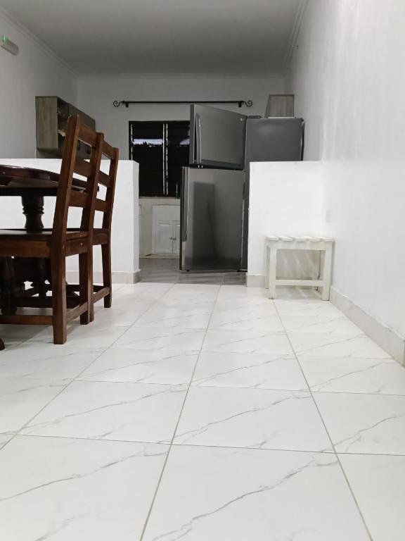 a kitchen with a white tiled floor and a table at Mobi house Malindi in Malindi