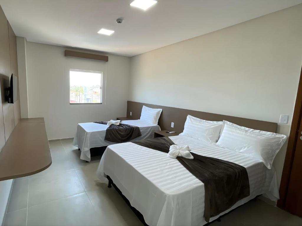 a bedroom with two beds and a window at Sun Route Hotel in Cabo de Santo Agostinho