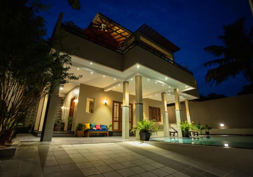 a villa with a swimming pool at night at Villa Freedom Hikkaduwa in Hikkaduwa