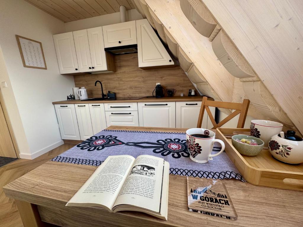 a kitchen with a table with two books on it at Wierchy Resort 21B by AWapartaments in Zakopane