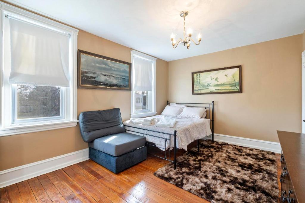 a bedroom with a bed and a chair and windows at Candlelight Chamber - Private Room with Shared Space in Chester