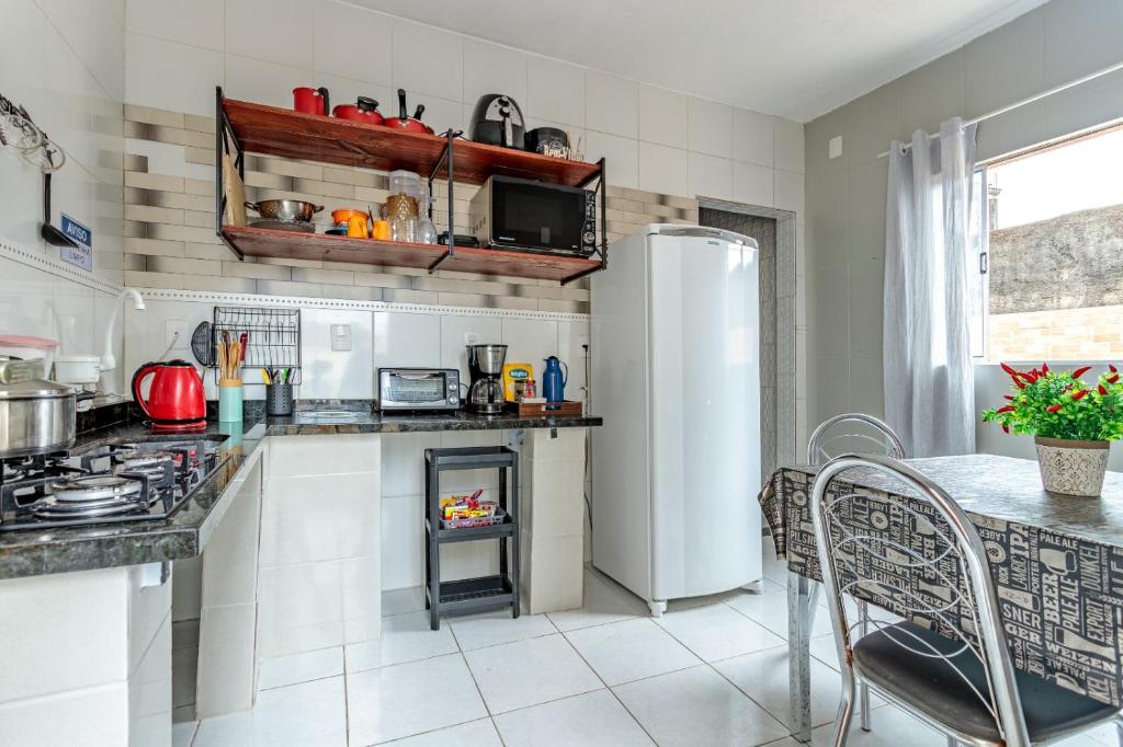 a kitchen with a refrigerator and a table at Casa perto do centro e da Udesc Cefid in Florianópolis