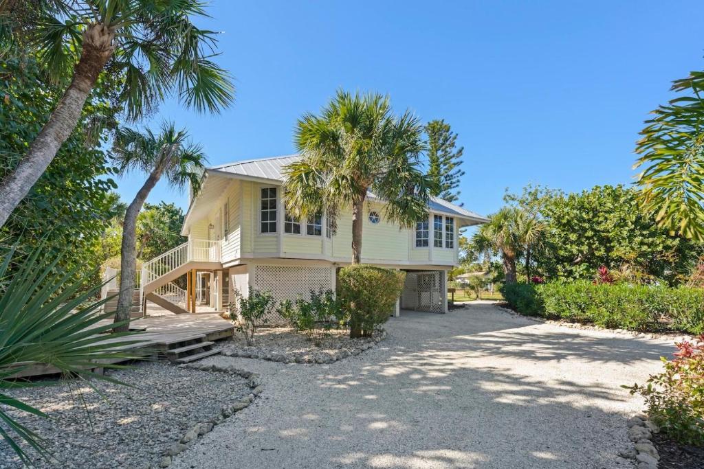a house with palm trees and a driveway at Lighthouse Lookout in Sanibel