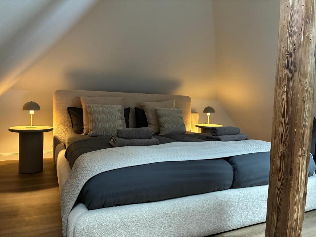 a bedroom with a bed and two tables with lamps at LYMA Suites - Apartment B44 in Immenstadt im Allgäu