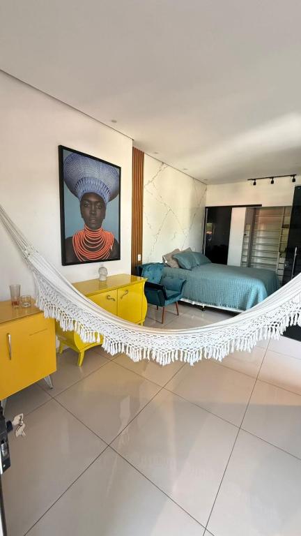 a bedroom with a bed and a painting of a woman at Flat Zona Sul in Teresina