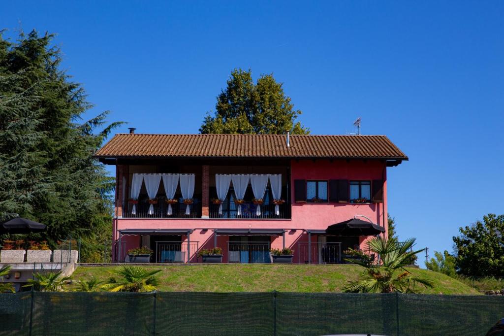 a large red house with a fence in front of it at Case Vacanze Marinella in Viverone