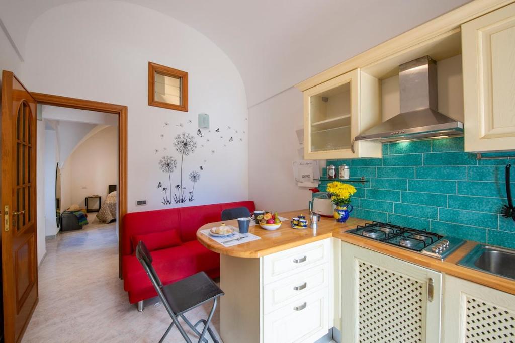a kitchen with a red couch in a room at Casa Alfonso in Minori