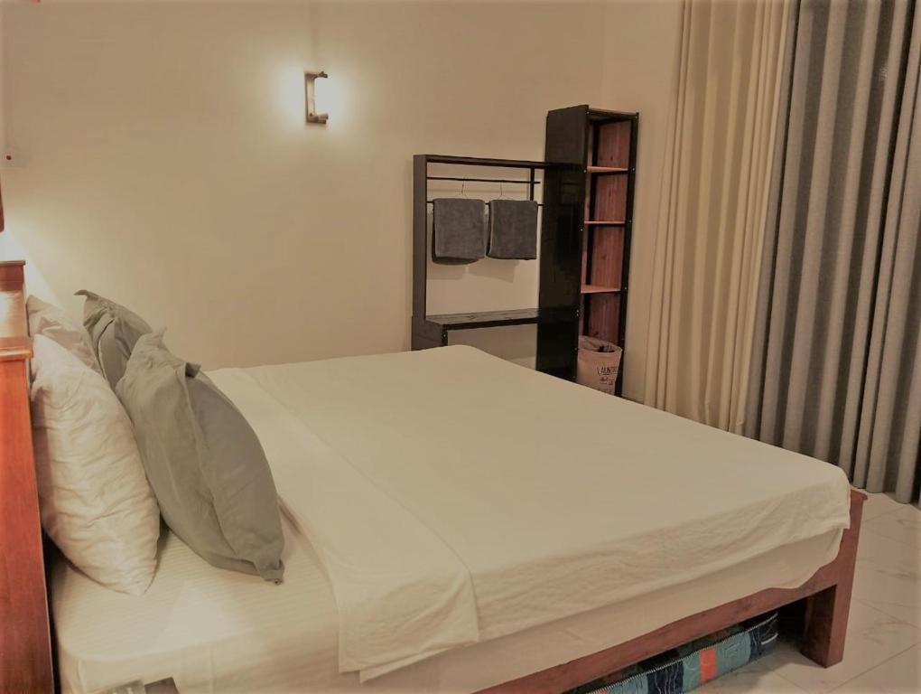 a bedroom with a bed with white sheets and pillows at Lisbon Lagoons in Negombo