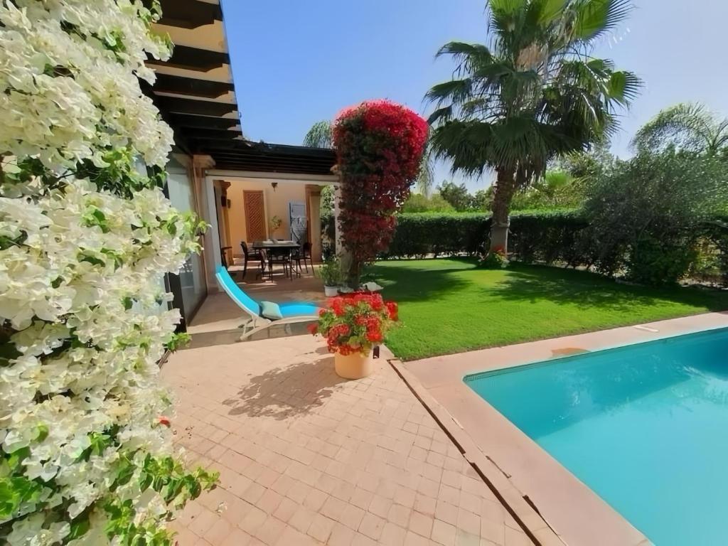 a house with a garden and a swimming pool at VILLA CHEZ IMANE avec piscine chauffée a Orangeraie Dyar Shemsi in Riaïna