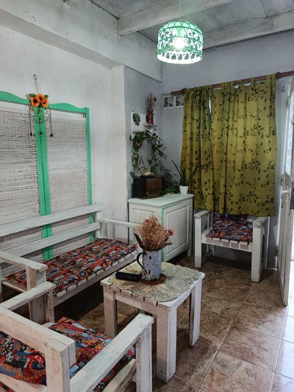a room with benches and a table and a chandelier at Verde limón in Olavarría