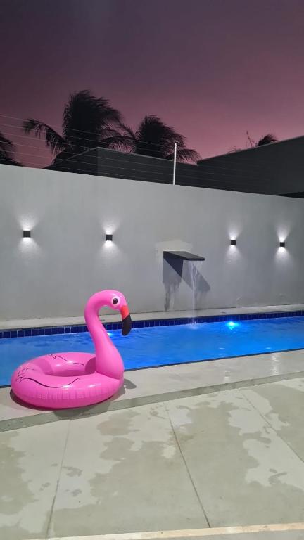 Ein rosa Schwan treibt in einem Schwimmbecken in der Unterkunft Casa Riso Dourado in Paracuru
