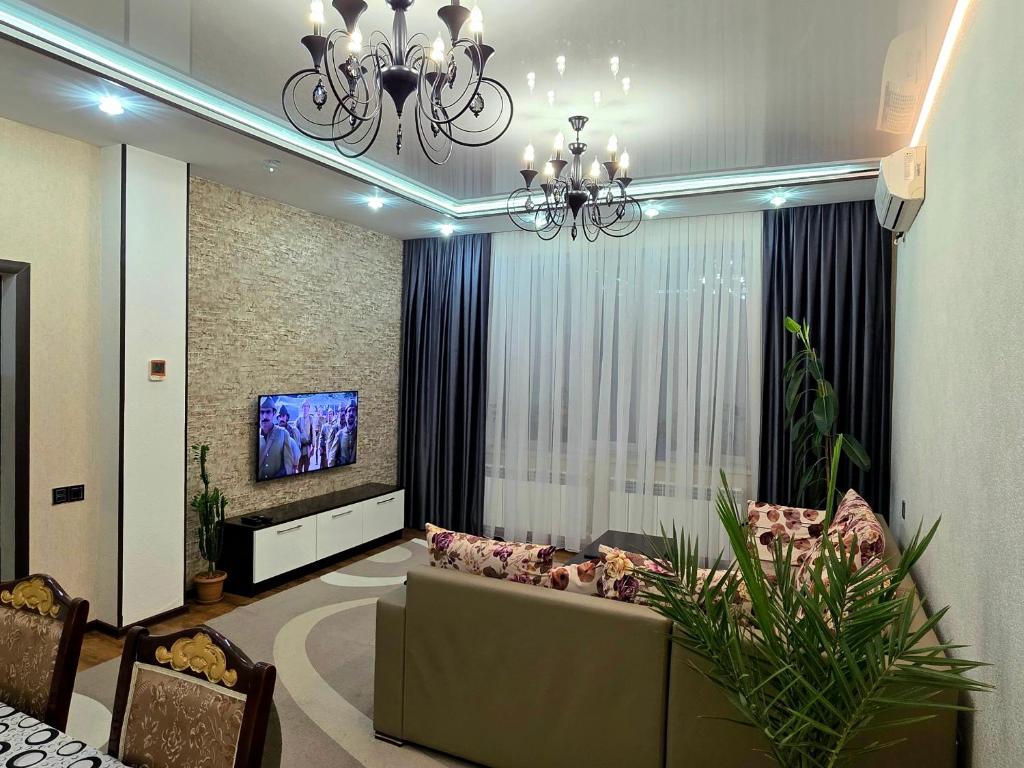 a living room with a couch and a tv at Dom Semya Gusar in Qusar