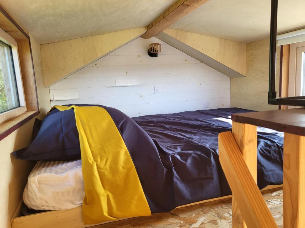 a bed in a small room in a tiny house at maison du bonheur in Tréflez