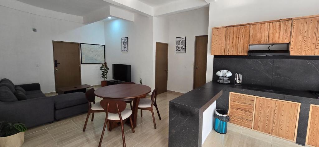 a kitchen and living room with a table and a couch at New, modern, amazing terrace in Taxco de Alarcón