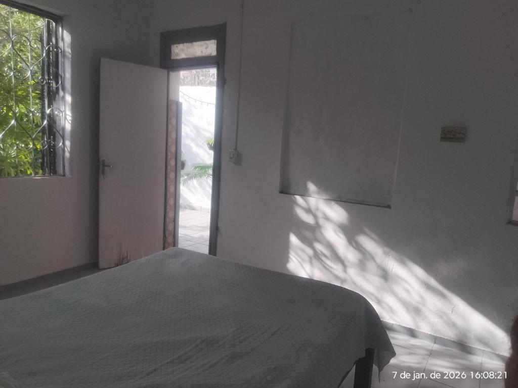a white bedroom with a bed and a window at Nelson Pinheiro in São Luís