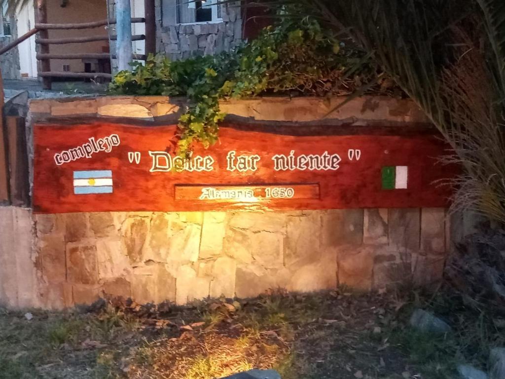 a sign on the side of a stone wall at Cabañas Dolce Far Niente in Tandil