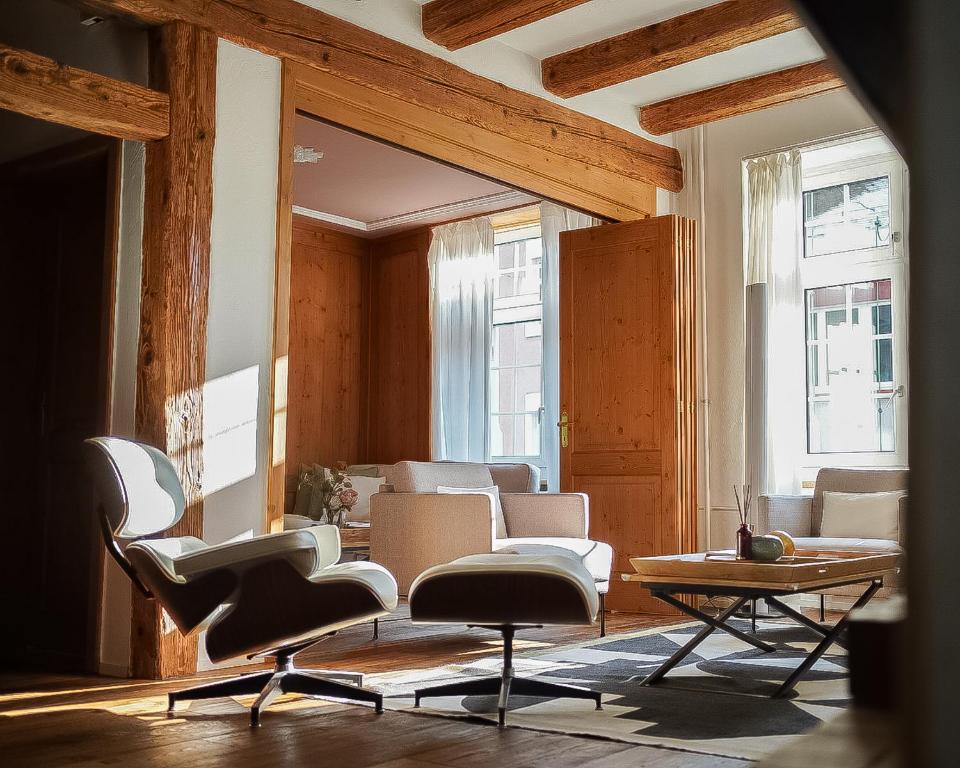 a living room with chairs and a table at Central Chalet Rooftop Maisonette in Old Town in Zurich