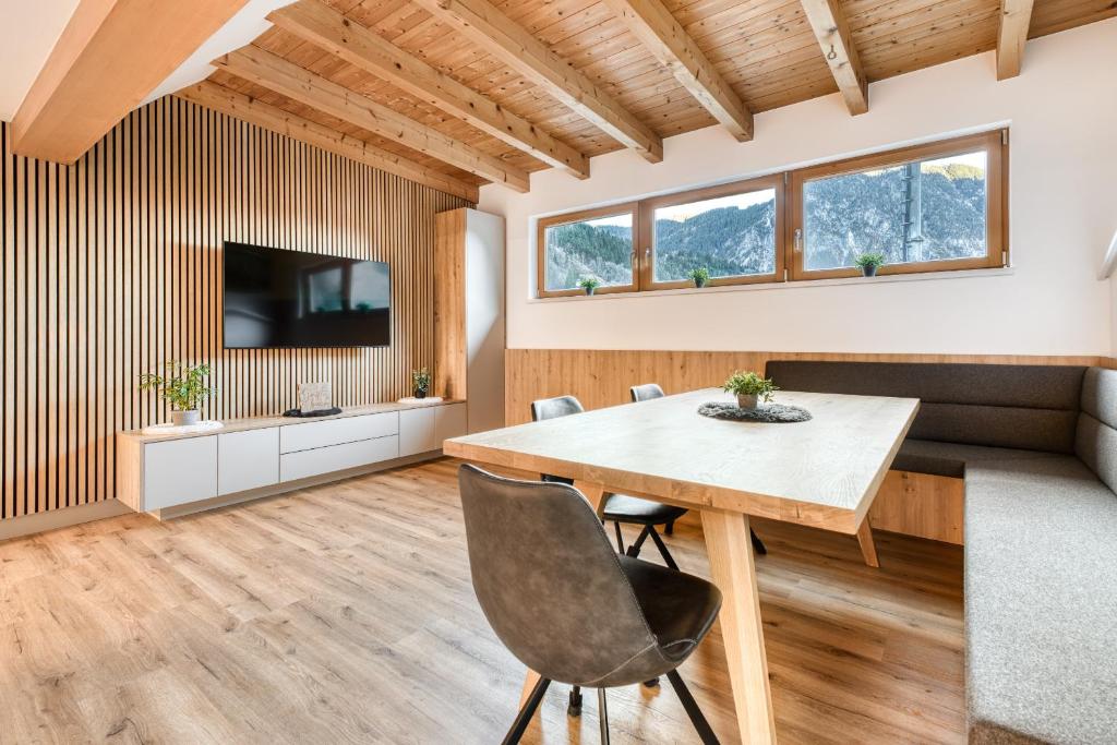 a dining room with a table and a tv at Ferienwohnung Gipfelstube in Brand