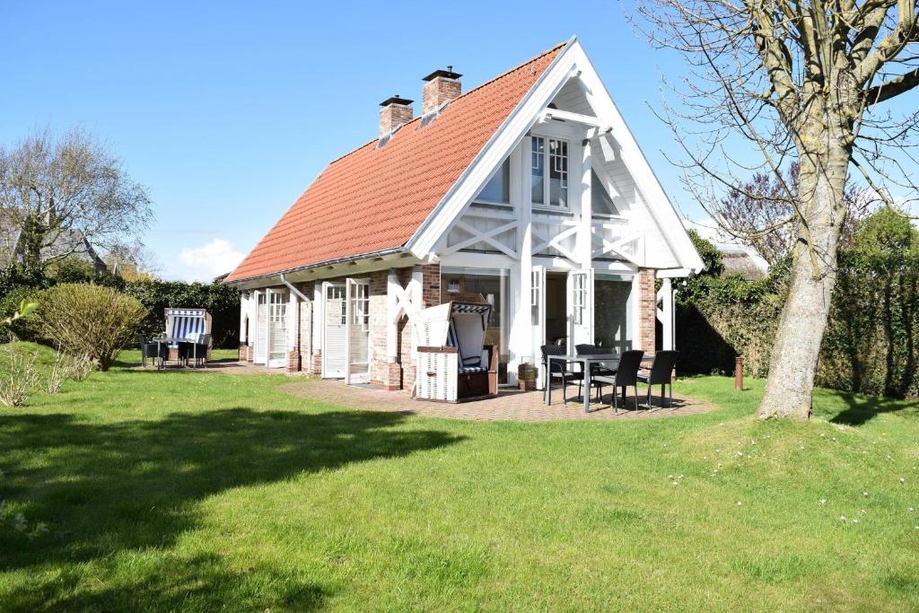 a small white house with a red roof at Brönswai 5A in Westerland