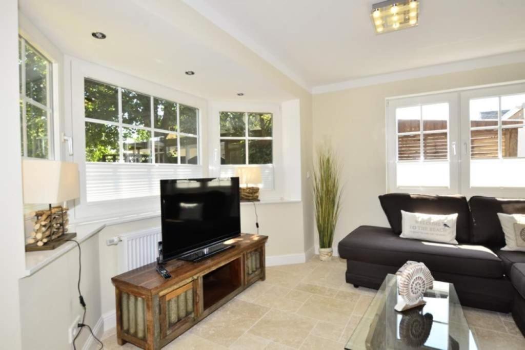 a living room with a couch and a flat screen tv at Ferienhaus Litj Stig in Westerland