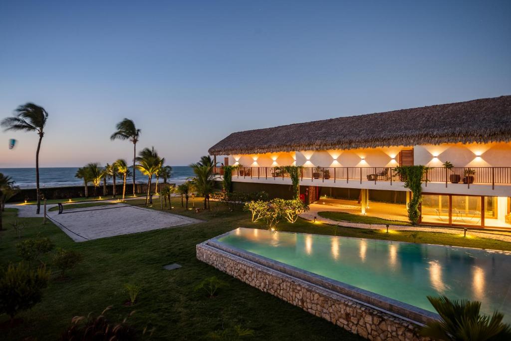 a building with a swimming pool in front of the ocean at Casa Siará - Hotel & Vilas in Prea