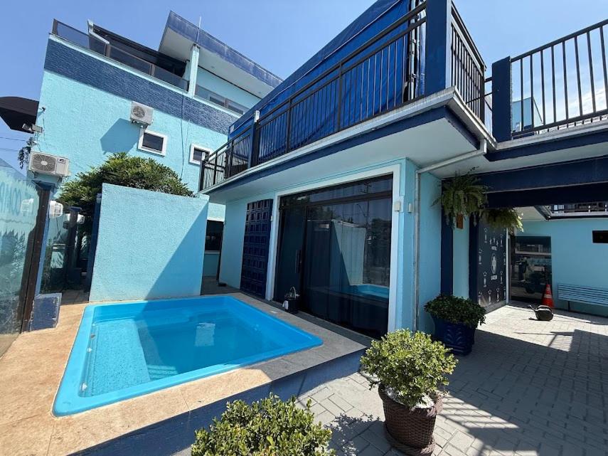 a house with a swimming pool next to a building at Hotel Mais Lazer - Hotel & Spa in Joinville