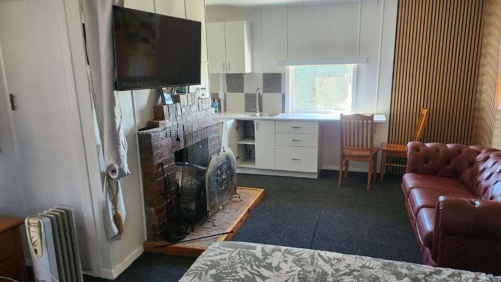 a living room with a couch and a fireplace at Rattrays Rd Farm Accomodation in Makikihi