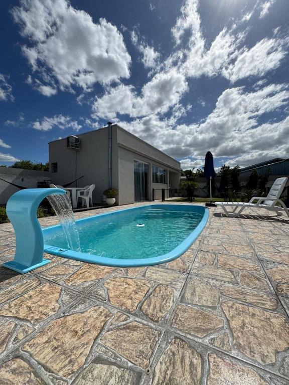 a swimming pool with a water fountain at Casa de descanso, completa, para ate 05 pessoas in Pântano Grande