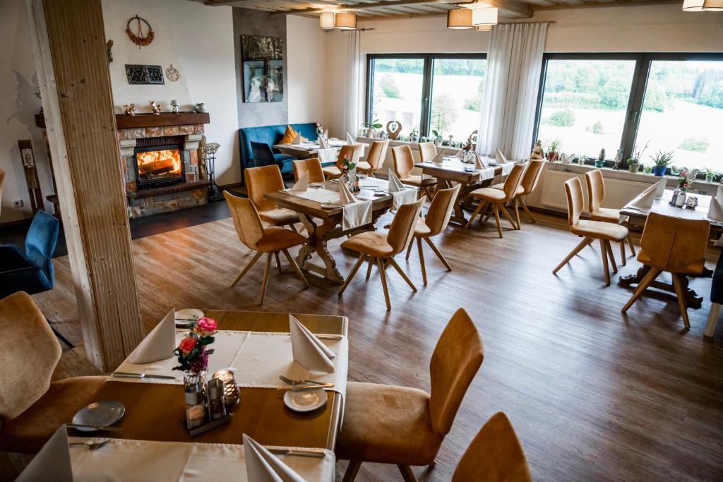 a restaurant with tables and chairs and a fireplace at Zur Kringelwies in Masburg