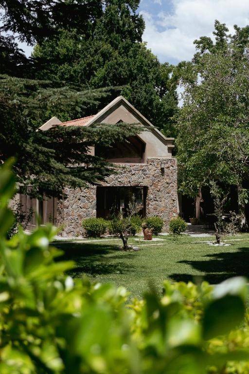 a stone house with a window in a yard at Casa Entonada - Hotel Boutique in Chacras de Coria