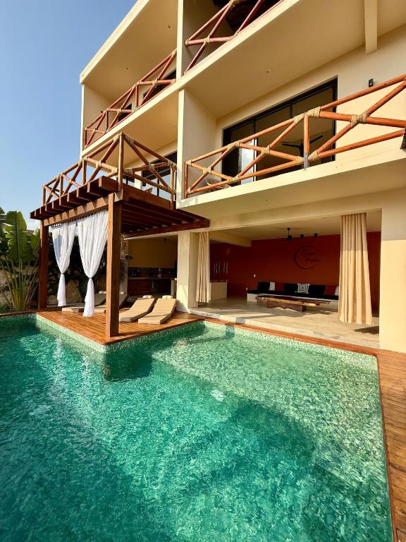 a villa with a swimming pool in front of a house at Luxury Ocean View Villa in Brisas de Zicatela