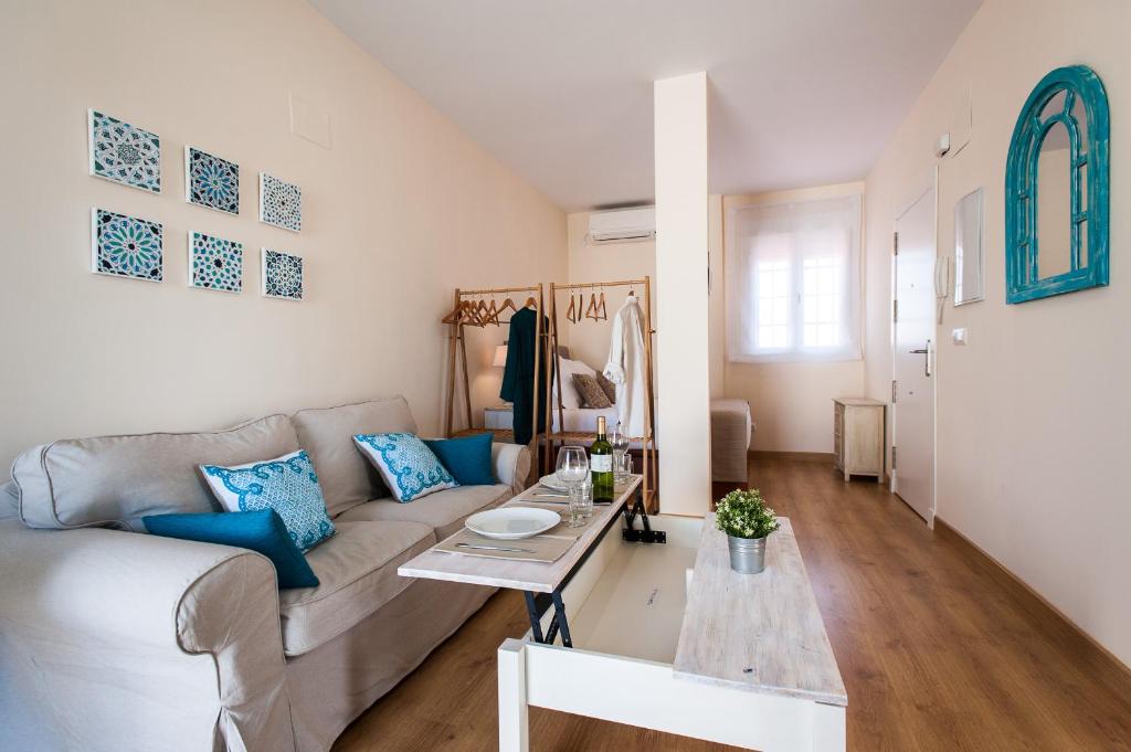 salon z kanapą i stołem w obiekcie Hommyhome Pozo Santo Penthouse w Sewilli